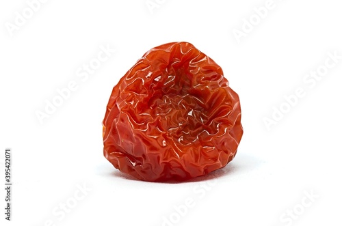 Rotten red cherry tomato on whote background. Studio shot of a vegetable