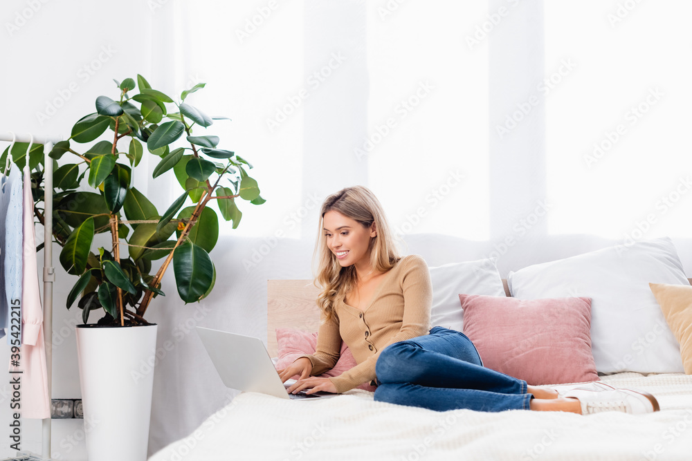 freelancer using laptop while working on bed at home freelancer using laptop while working on bed at home