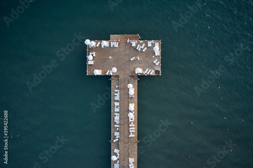 Aerial view of pier in the sea. Aerial drone view of wooden pier on turquoise water at the Mediterranean sea. Summer holidays concept.