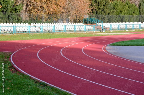 Red treadmill with white lines in a sports stadium. Red running tracks in the stadium. Empty sport stadium. Treadmill is covered with red rubber coating. 