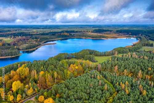 Fototapeta Naklejka Na Ścianę i Meble -  Aerial view of Omulew lake under blue cloudy sky