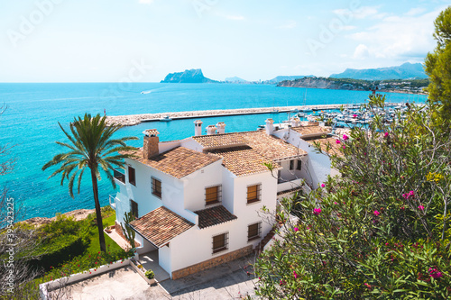 Traditional white houses with unspoilt idyllic view of marina, coastline and Mediterranean Sea in Moraira, Costa Blanca, Spain