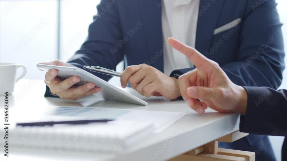 Professional businessman in suit using tablet meeting about business finance, working in office Professional businessman in suit using tablet meeting about business finance, working in office