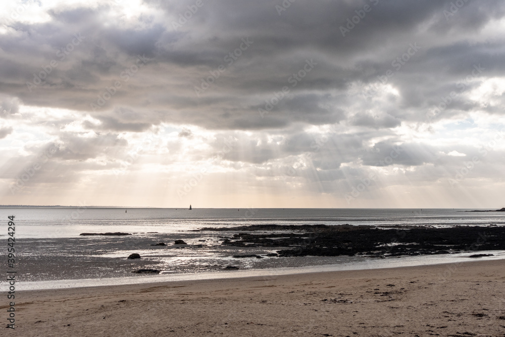 View on a beach in Saint-Nazaire, in the west of France. Cloudy sky that lets rays of light pass through. Cloudy sky, ray of light.