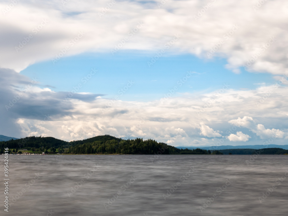View of the lakes in Hønefoss, a town not far from Oslo, Norway. Cloudy sky. The clouds form a circle.