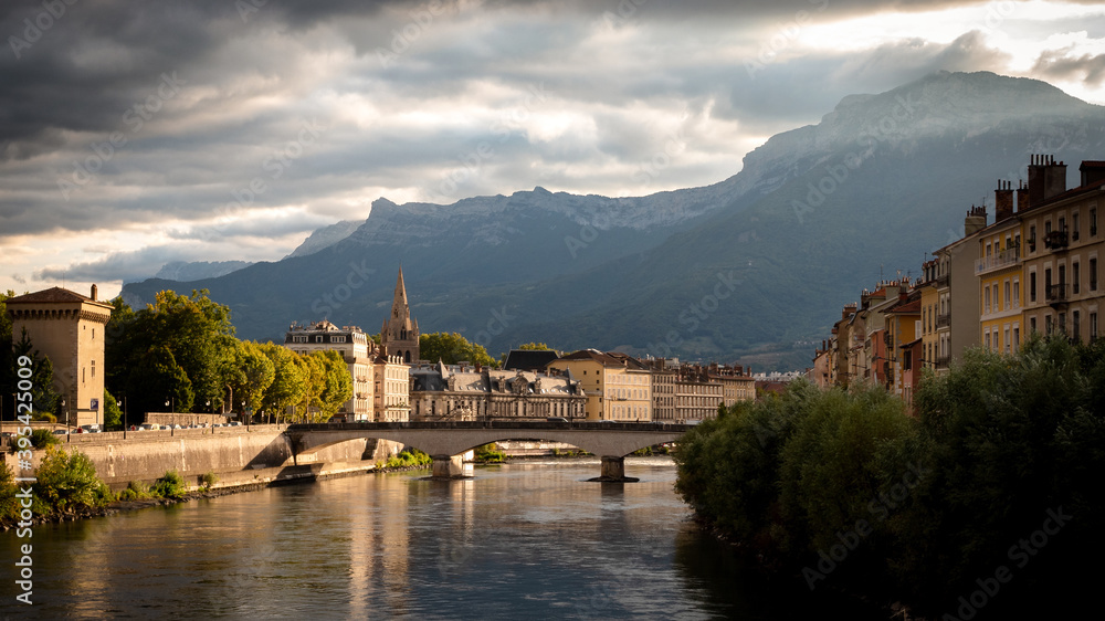 View on the Isère river in Grenoble, France. Photographed in the evening. Grenoble is the prefecture and largest city of the Isère department in the Auvergne-Rhône-Alpes region of Southeastern France.