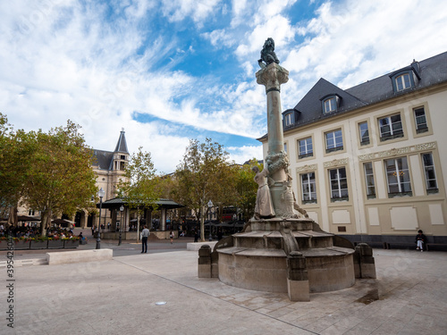 The Place d'Armes is a square in Luxembourg City in the south of the Grand Duchy of Luxembourg. Dicks-Lentz monument in the foreground. Cloudy sky. 