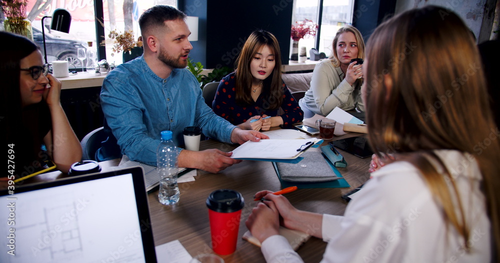 Healthy workplace concept. Confident young businessman instructing multiethnic team at business meeting slow motion. Healthy workplace concept. Confident young businessman instructing multiethnic team at business meeting slow motion.
