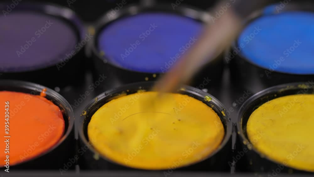 artist painter mixing water and yellow watercolor with brush 4k artist painter mixing water and yellow watercolor with brush 4k