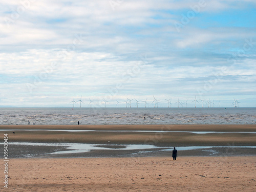 the beach at blundell flats in sefton, southport with pools on the beach the beach and the wind turbines at burbo bank visible in the distance