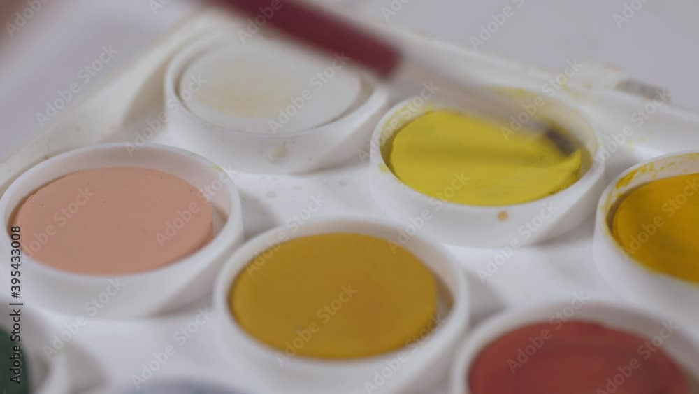 artist painter mixing water and yellow watercolor with brush 4k