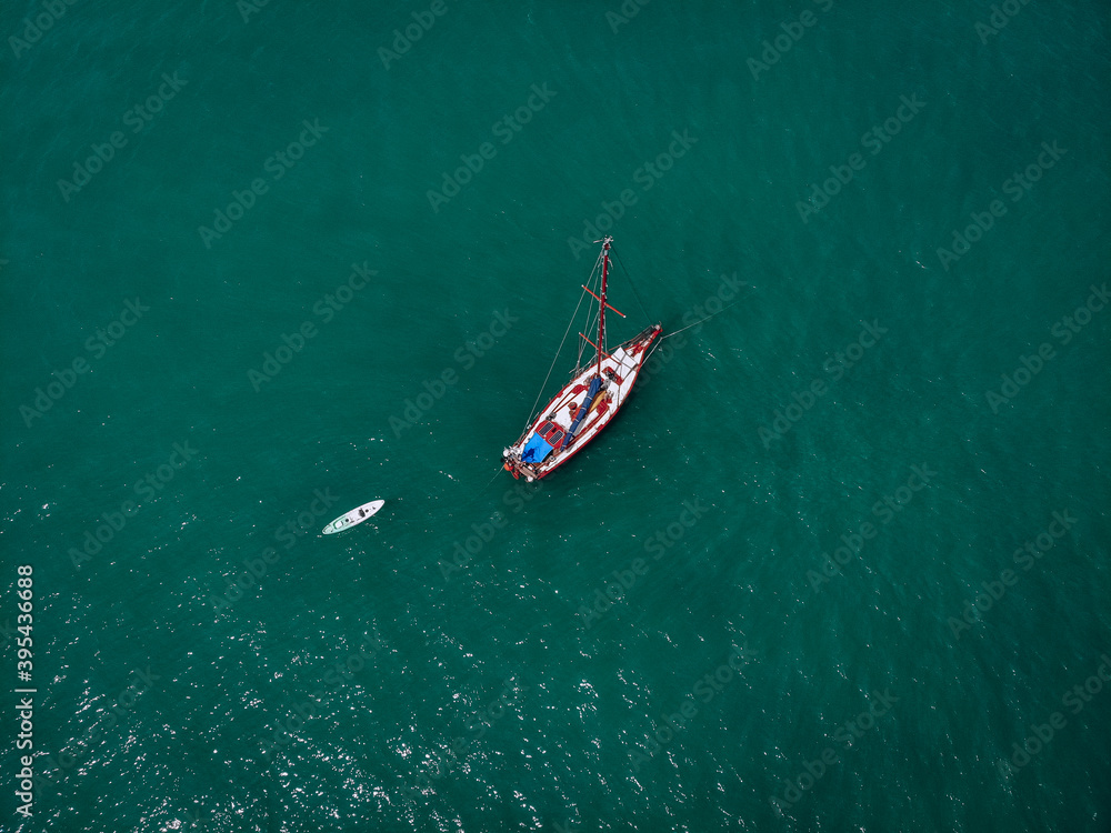 Aerial view of a sailing yacht with white kayak in the turquoise water of the Andaman sea. Phuket. Thailand Aerial view of a sailing yacht with white kayak in the turquoise water of the Andaman sea. Phuket. Thailand