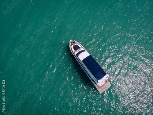 Aerial photo of an isolated luxury white  yacht with blue roof design in the sea © Semachkovsky 