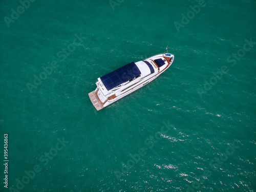 Aerial photo of an isolated luxury white  yacht with blue roof design in the sea © Semachkovsky 