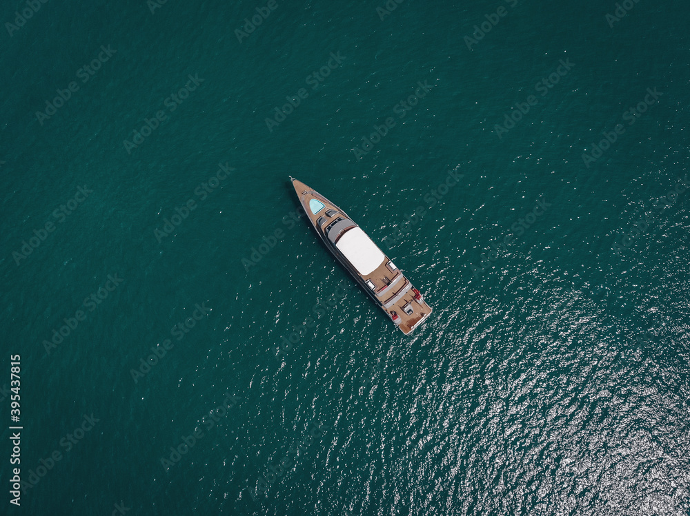 Aerial picture of an isolated yacht with brown wooden design in the sea Aerial picture of an isolated yacht with brown wooden design in the sea