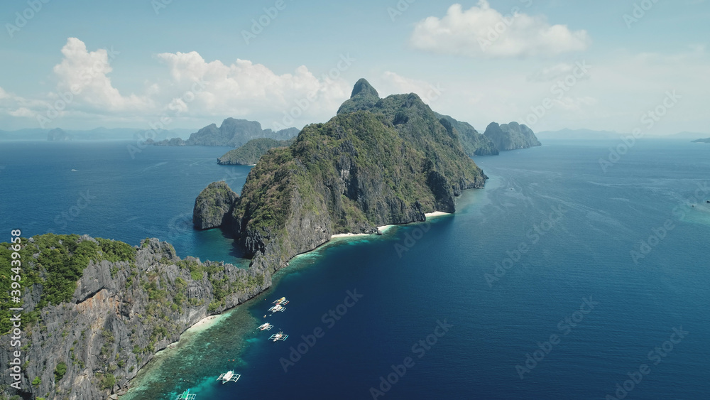 Amazing seascape at tropical islands of Philippines Archipelago aerial view. Summer cruise scenery at mountainous isles. Traditional passenger boats at blue sea coast. Cinematic drone soft light shot