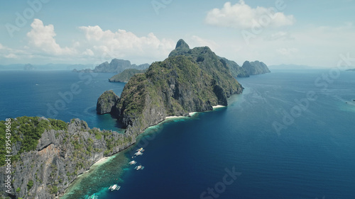 Amazing seascape at tropical islands of Philippines Archipelago aerial view. Summer cruise scenery at mountainous isles. Traditional passenger boats at blue sea coast. Cinematic drone soft light shot © Goinyk