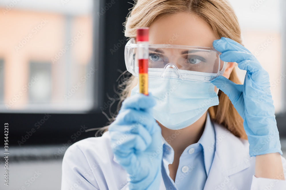scientist in goggles, latex gloves and medical mask holding test tube with covid lettering, stock image scientist in goggles, latex gloves and medical mask holding test tube with covid lettering, stock image