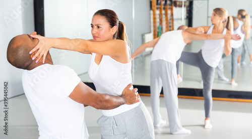 Canvas Print Hispanic girl using painful technique for eyes of opponent during training at gym
