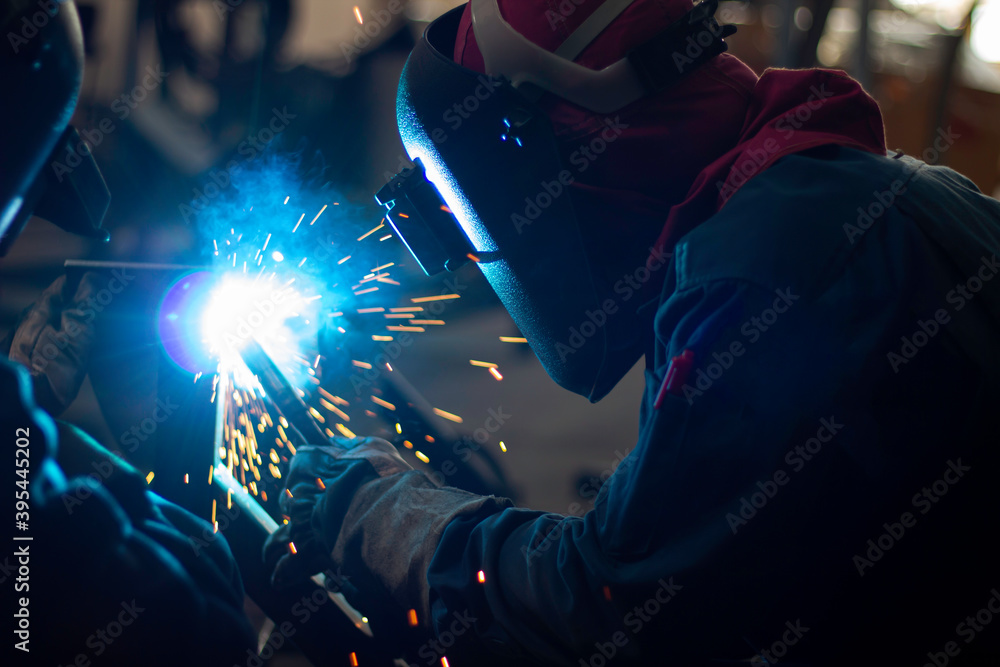 Metal workers use manual labor, Skilled welder, Factory workers making OT. Welder is welding the steel in the factory. Metal workers use manual labor, Skilled welder, Factory workers making OT. Welder is welding the steel in the factory.