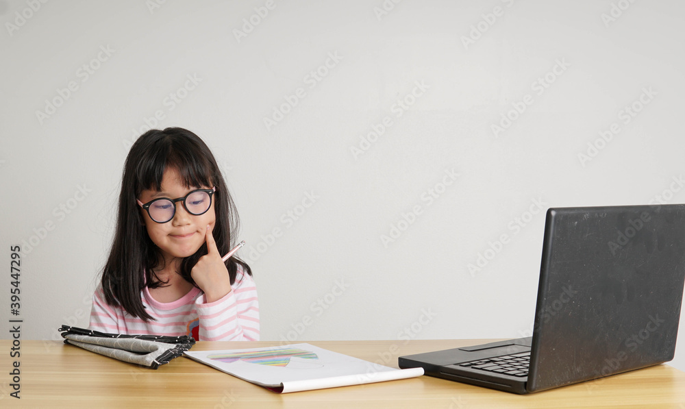young girl with laptop in front and studying online through remote computer during home quarantine young girl with laptop in front and studying online through remote computer during home quarantine