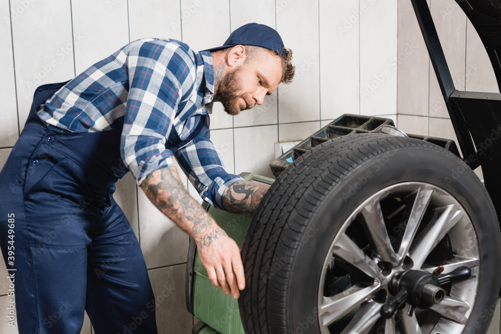 mechanic checking wheel on balance control machine mechanic checking wheel on balance control machine