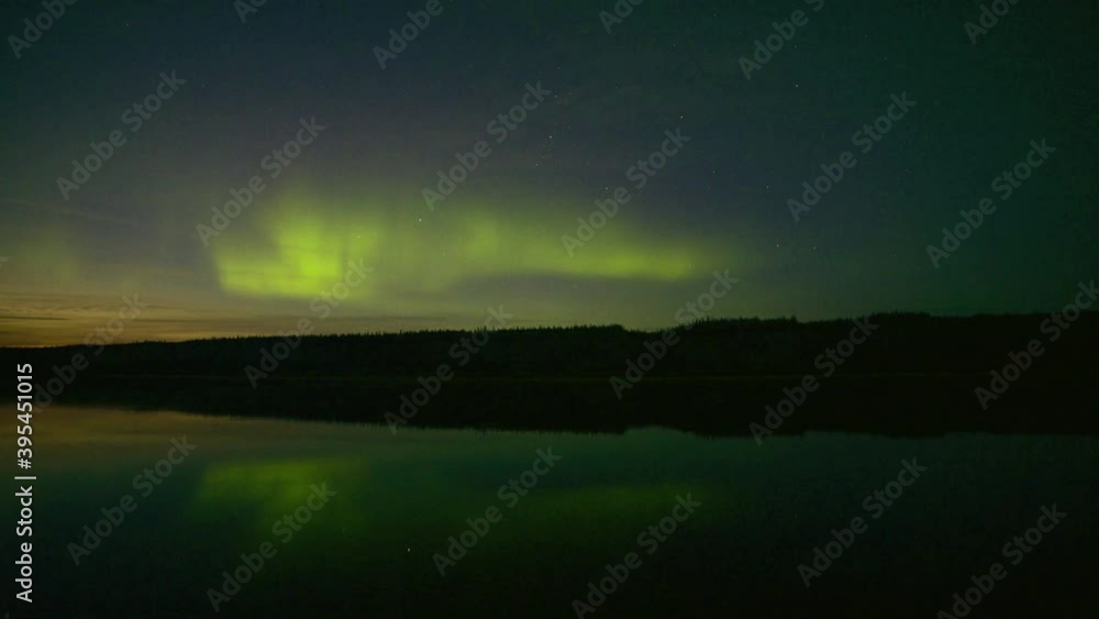 Aurora borealis at sunset with movement over the Teslin River in Yukon Territory, northern Canada. Taken in fall, autumn at the start of the northern lights season. Aurora borealis at sunset with movement over the Teslin River in Yukon Territory, northern Canada. Taken in fall, autumn at the start of the northern lights season.