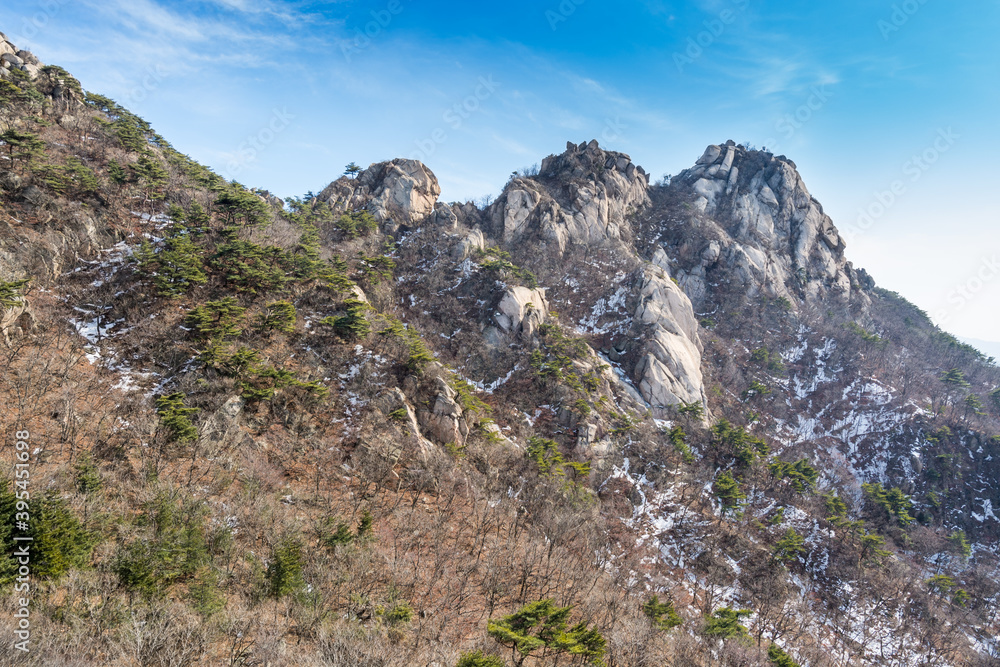 Bukhansan Mountain national park with rocks, snow, and dead trees in the spring in Seoul of South Korea.