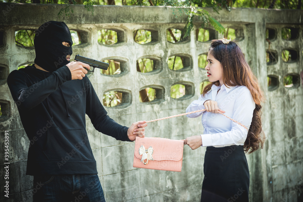 The robber is robbing the female with a gun pointing the gun to the