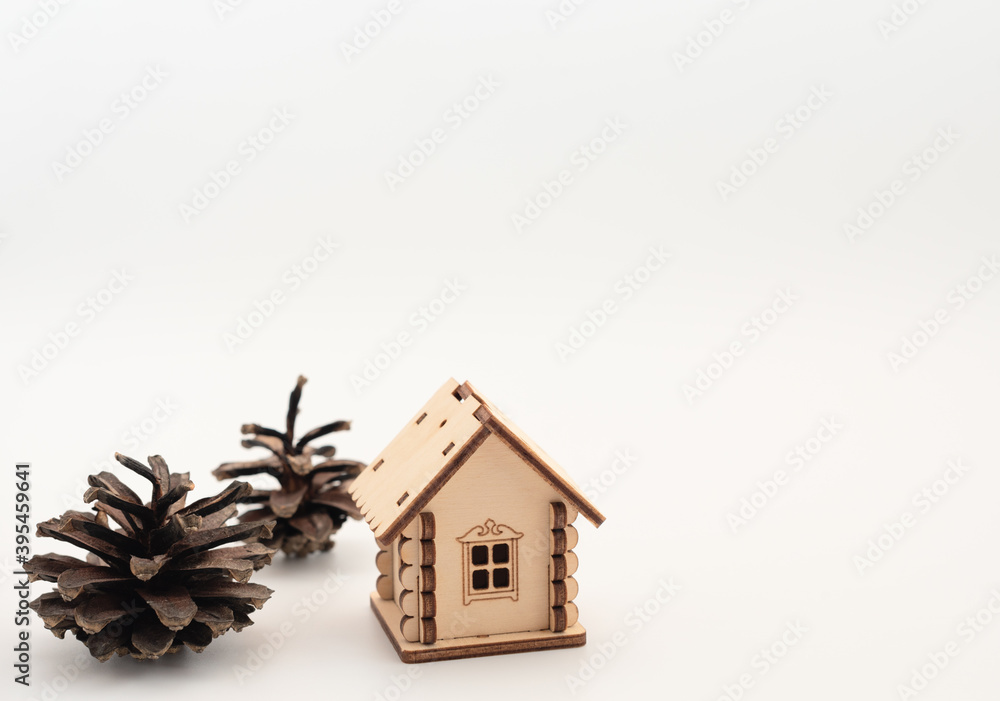 Wooden house with pine cones like a tree on white background. Staying at home during Christmas, New Year  holidays concept. Isolation and coronavirus pandemic in the world. Winter card.