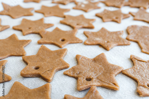 gingerbread cookie dough cut into stars prepared to be baked on parchment paper