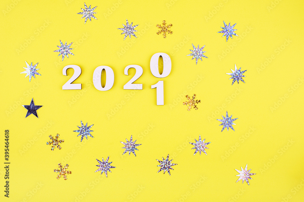 Close-up of wooden numbers 2021 on yellow background with stars . Change year 2020 to 2021. Holidays content Close-up of wooden numbers 2021 on yellow background with stars . Change year 2020 to 2021. Holidays content