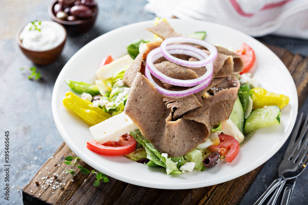 Gyro salad with thinly sliced meat and vegetables, healthy greek inspired lunch Gyro salad with thinly sliced meat and vegetables, healthy greek inspired lunch