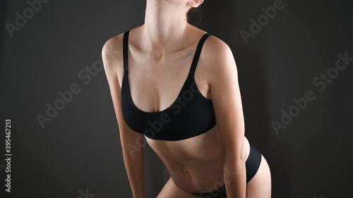 Close-up view of beautiful slim woman body in black underwear in the studio. Beautiful breasts in a sports braA concept for medicine and cosmetology.  photo