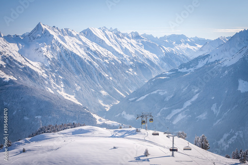 Panorama of Mayrhofen with ski lifts and cable car, Zillertal, Austria. Penken ski area. Mountains and fir trees covered with snow. Frosty morning