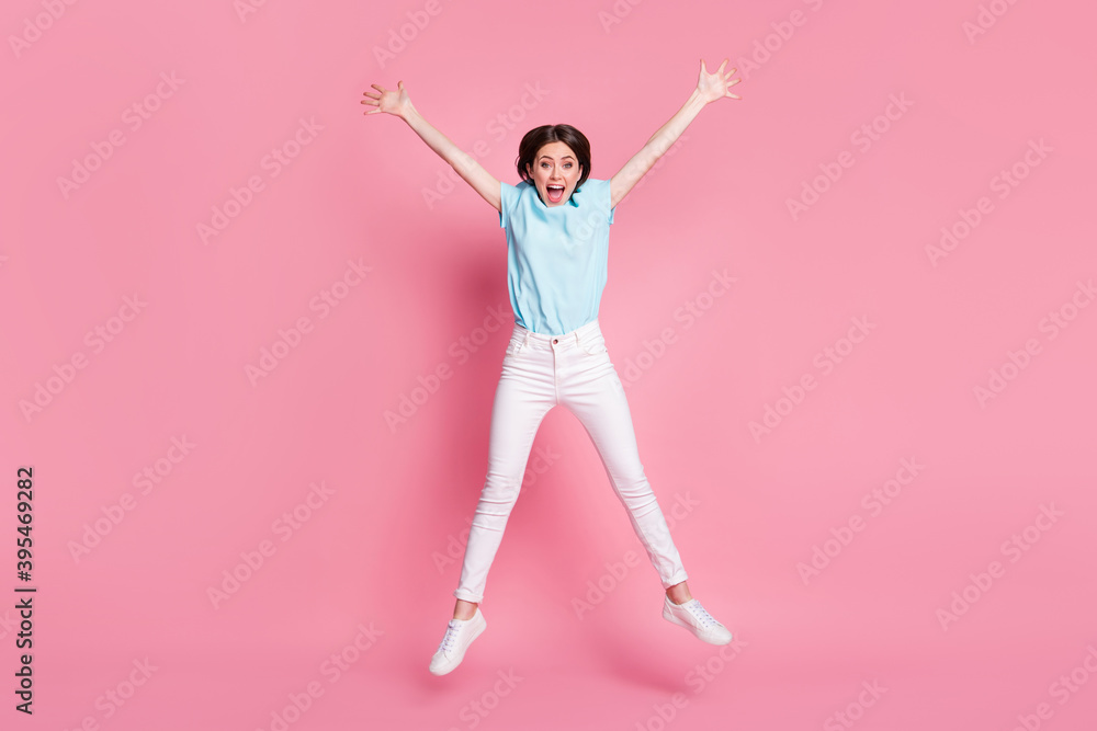 Full length photo of crazy carefree girl jump raise hands isolated over pink color background