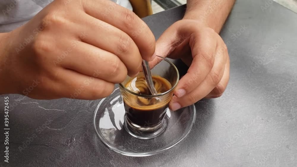 man sitting at the table and mixing coffee, closeup man sitting at the table and mixing coffee, closeup