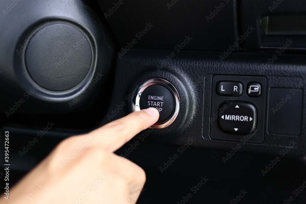Engine start button, Press the button to start the car automatically. Car start stop system with finger pressing the button. Engine start button, Press the button to start the car automatically. Car start stop system with finger pressing the button.