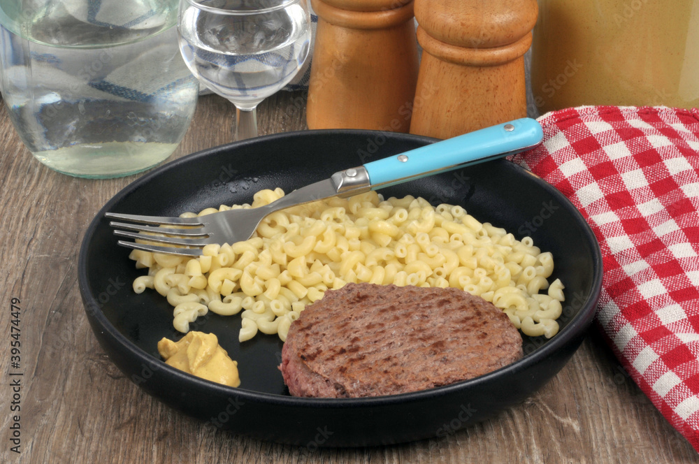 Assiette de pâtes avec un steak haché et de la moutarde servie à table Stock Photo Adobe Stock