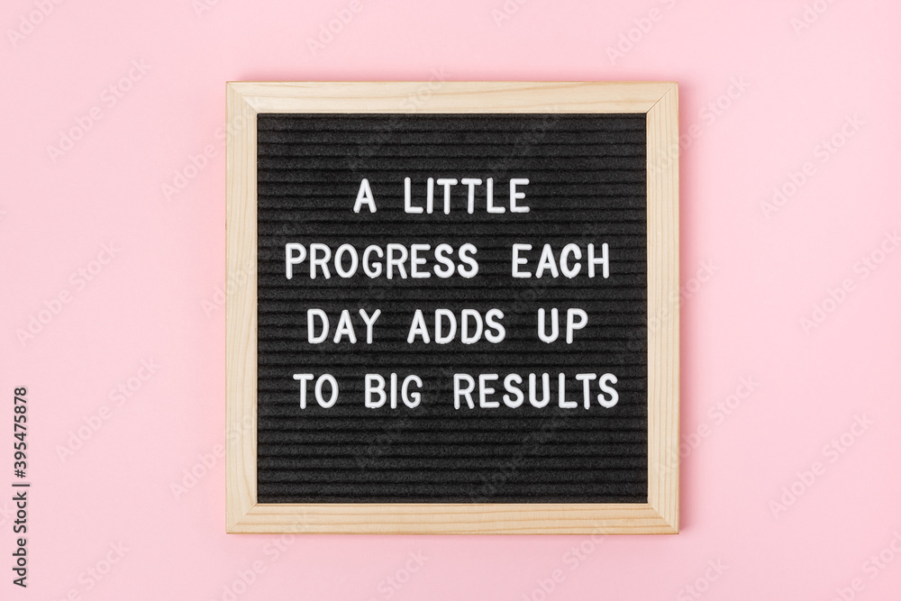 Fototapeta A little progress each day adds up to big results. Motivational quote on black letter board on pink background. Concept inspirational quote of the day. Greeting card, postcard.