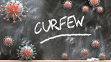 Curfew and covid virus - pandemic turmoil and Curfew pictured as corona viruses attacking a school blackboard with a written word Curfew, 3d illustration