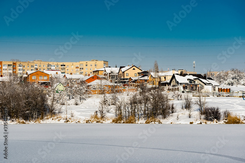 Multi-storey residential buildings made of white and red brick with plastic Windows, stand in winter under a layer of white lush snow in frosty Sunny weather. © Анна Иванова
