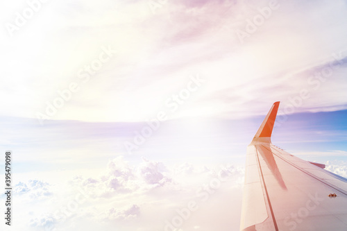 Plane wings in the sky with fluffy white clouds