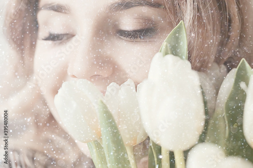 spring snowfall beautiful girl with flowers / concept of international women’s day march, gift for girlfriend, happiness