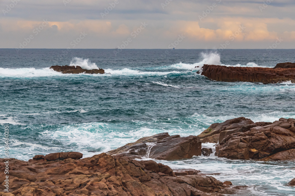 Rocky Seascape with Blue Aquamarine Sea and Earthy Brown Rocks