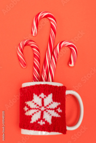 top view of candy canes in mug on red 