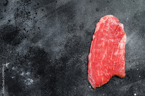 Raw flank steak. Marble beef black Angus. Black background. Top view. Copy space
