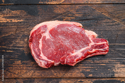 Ribeye steak. Raw Marble beef black Angus, rib eye. Dark wooden background. Top view