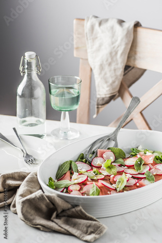 Watermelon, radish, mint and feta cheese salad. Spiced with olive oli, sea salt and black pepper photo