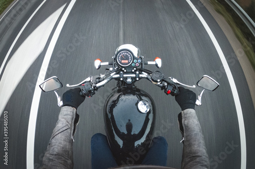 Driving a vintage old black motorbike on a straight asphalt tarmac road highway